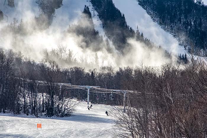 Skiers in Distance Under Chairlift