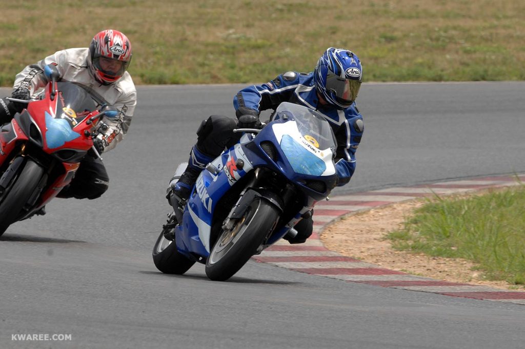 Two Sport Bikes Riding Around Curve in Track