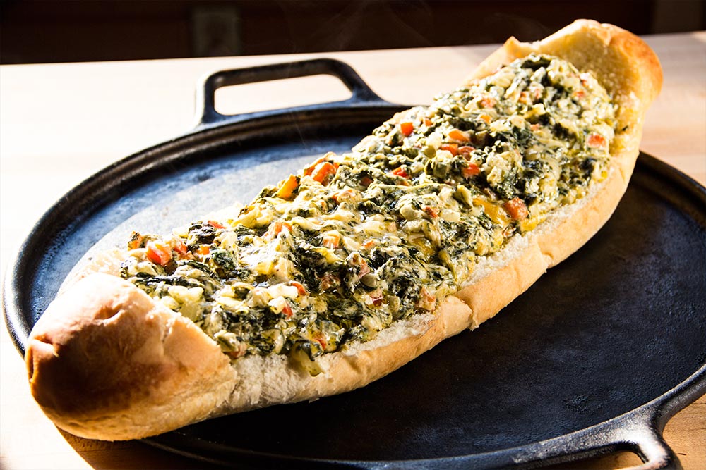 Adding Spinach Dip to French Bread