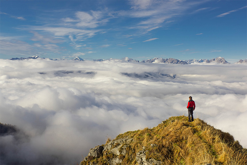 Standing on Mountain Above Clouds