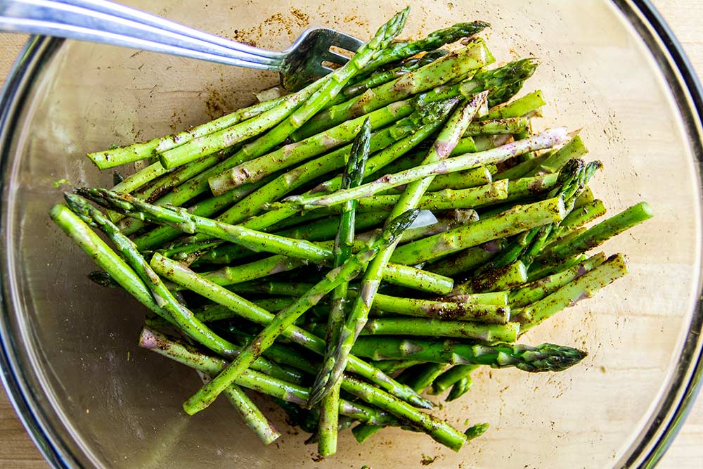 Marinating Asparagus with Paprika & Olive Oil in Glass Bowl